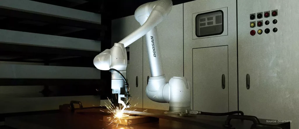Doosan collaborative robot (CoBot) welding a metal surface in a factory environment, demonstrating human-safe, flexible automation