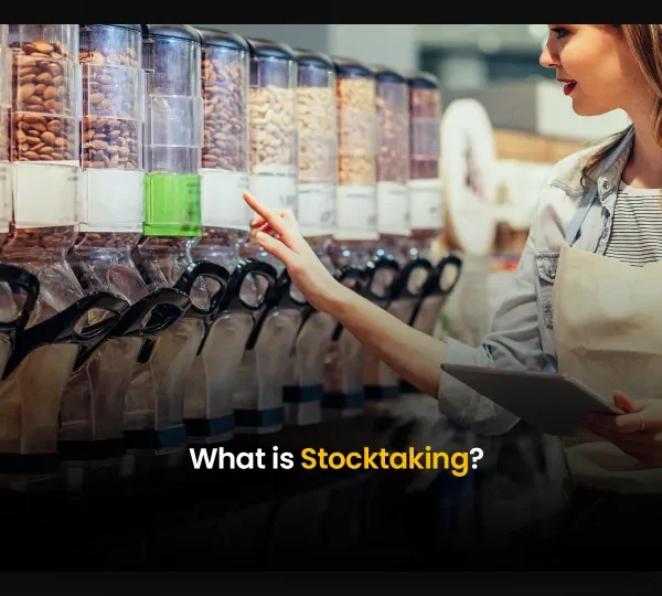 Retail worker performing stocktaking with a tablet in front of product dispensers – showcasing digital inventory management in action.
